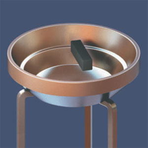 Рис. 7. Постоянный магнит длиной несколько сантиметров парит на расстоянии чуть больше 1 см над дном сверхпроводящей чашечки, поставленной на три медные ножки. Ножки стоят в жидком гелии, а чашечка находится в парах гелия для поддержания сверхпроводящего состояния